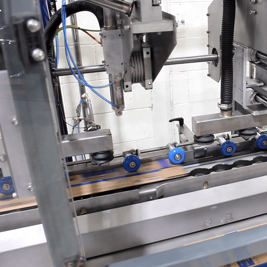Cartoner for forming long double-wall cartons with automatic bottom stapling